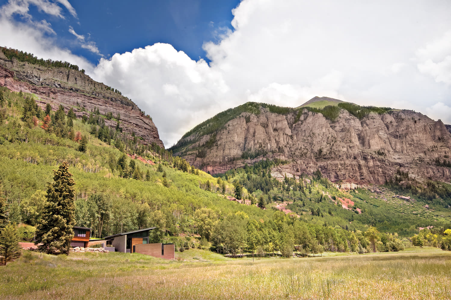 Panoramic view of peaks with home with modern architecture nestled in the valley