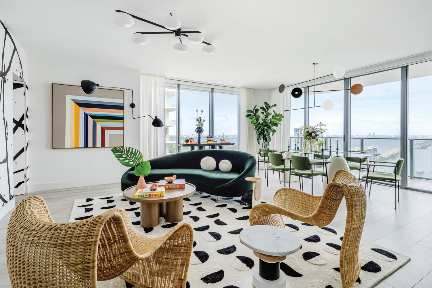 living room with curved wicker chairs, patterned rug and multicolored artwork