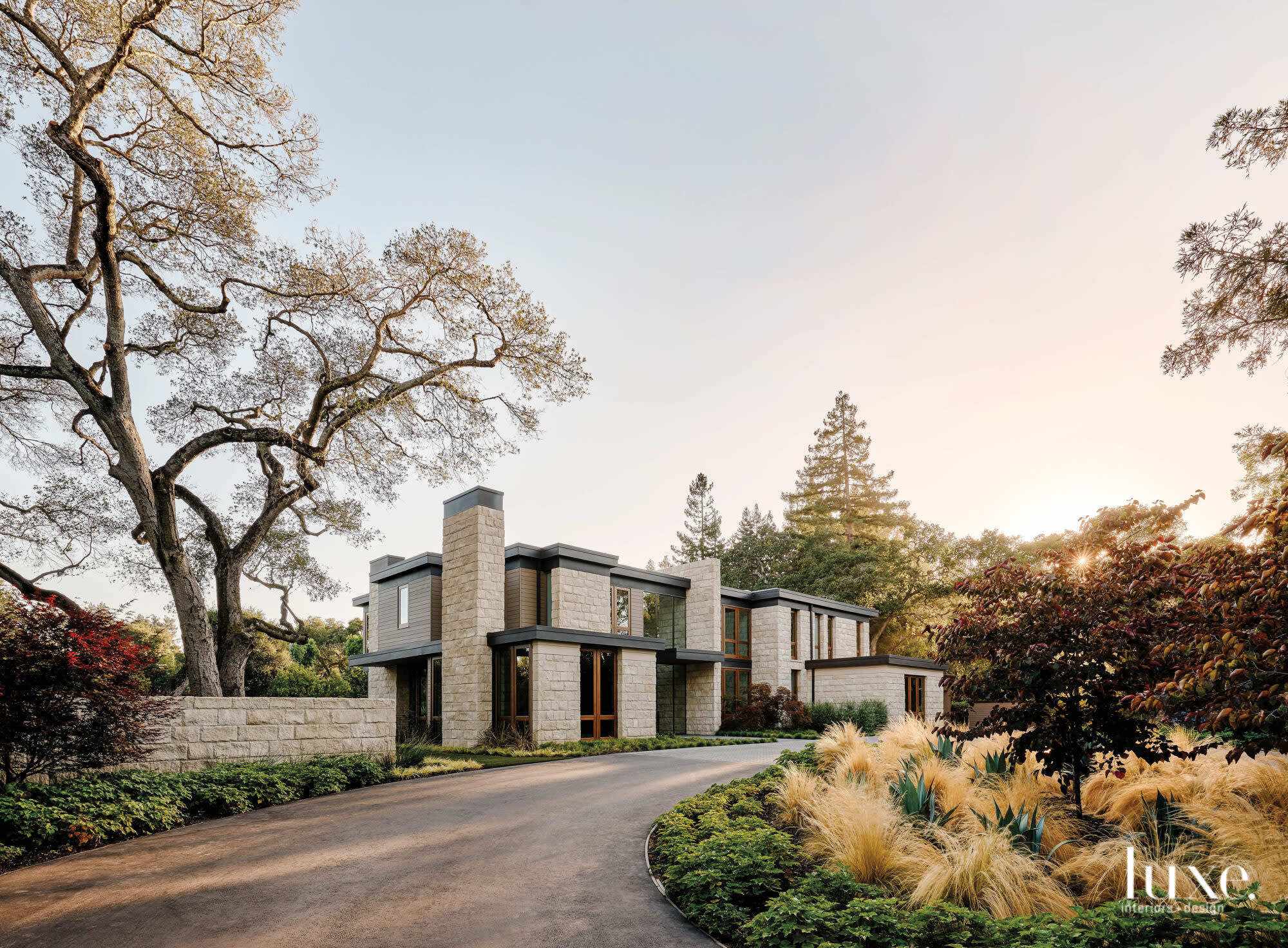 A modern house sits amidst a lush landscape.