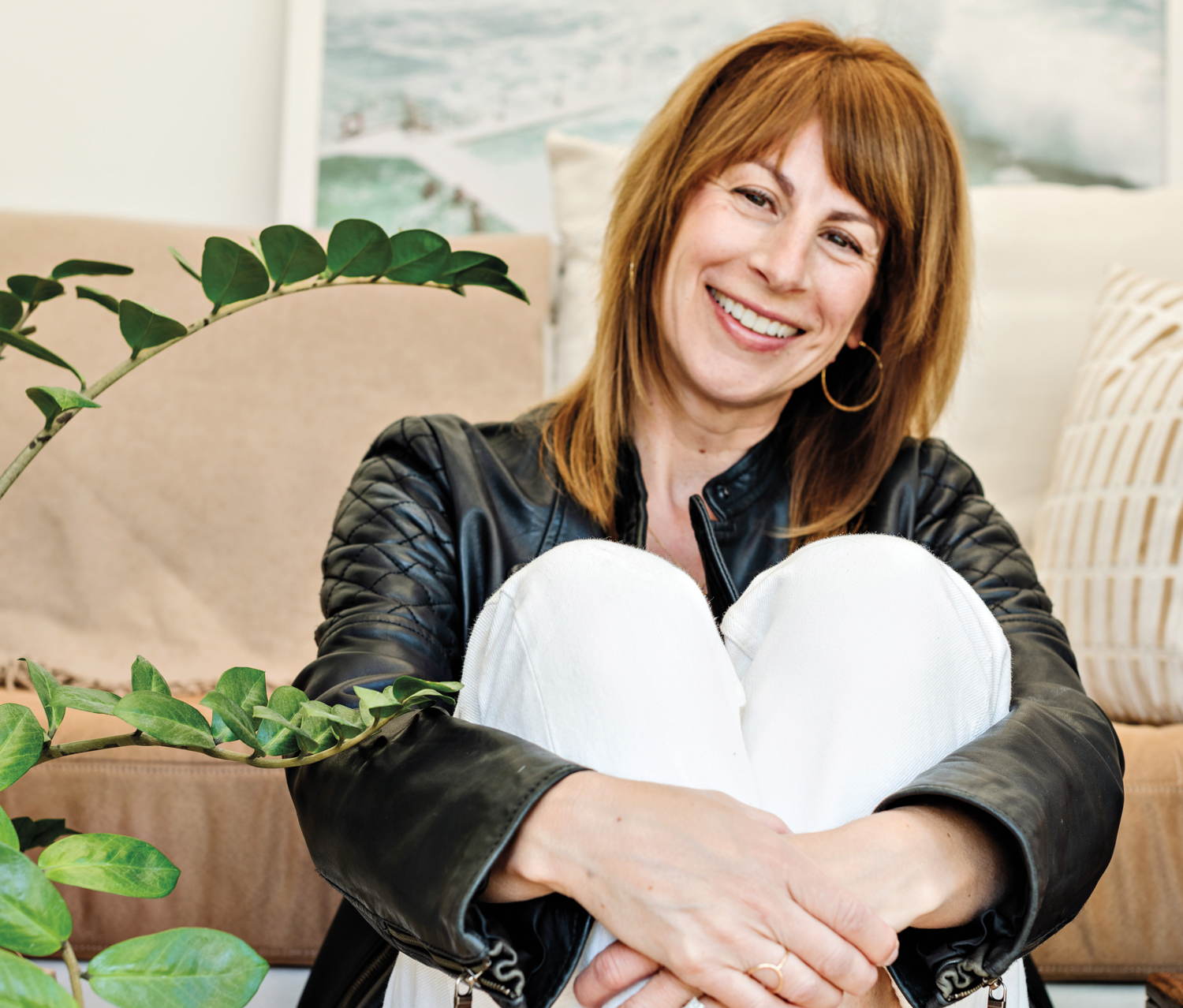 Portrait shot of Candice Truempert-Lee sitting in front of beige sofa
