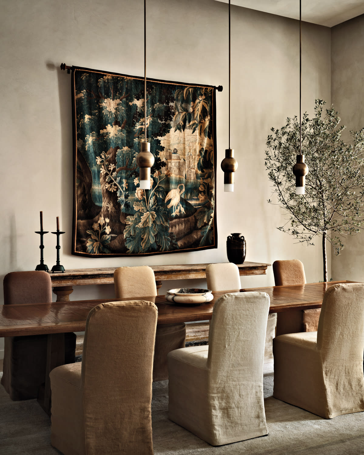 contemporary, warm dining room with a vintage tapestry on the wall