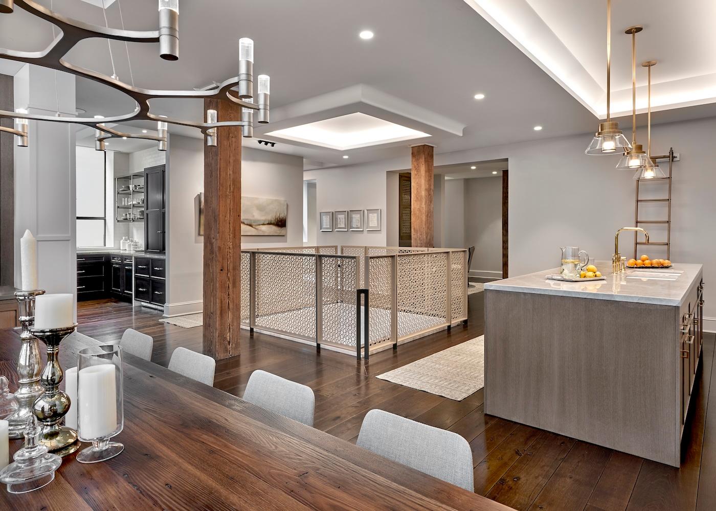 Spacious modern kitchen with dark wood floors, large island, and elegant lighting. Cozy dining area with candles, and open layout with soft tones.