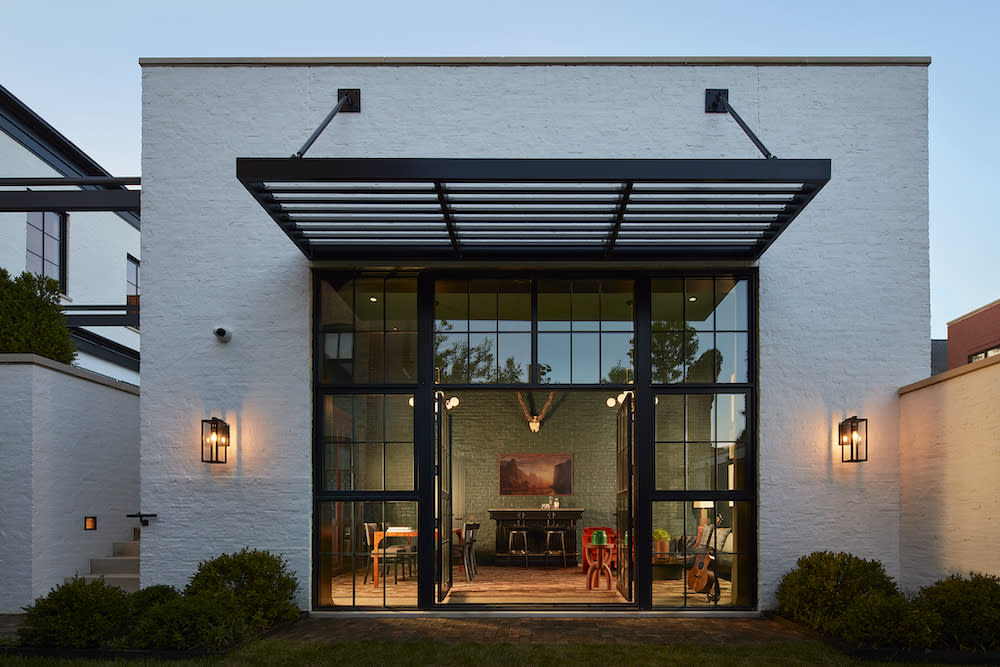 Exterior view looking into office. White brick, steel slatted awning.