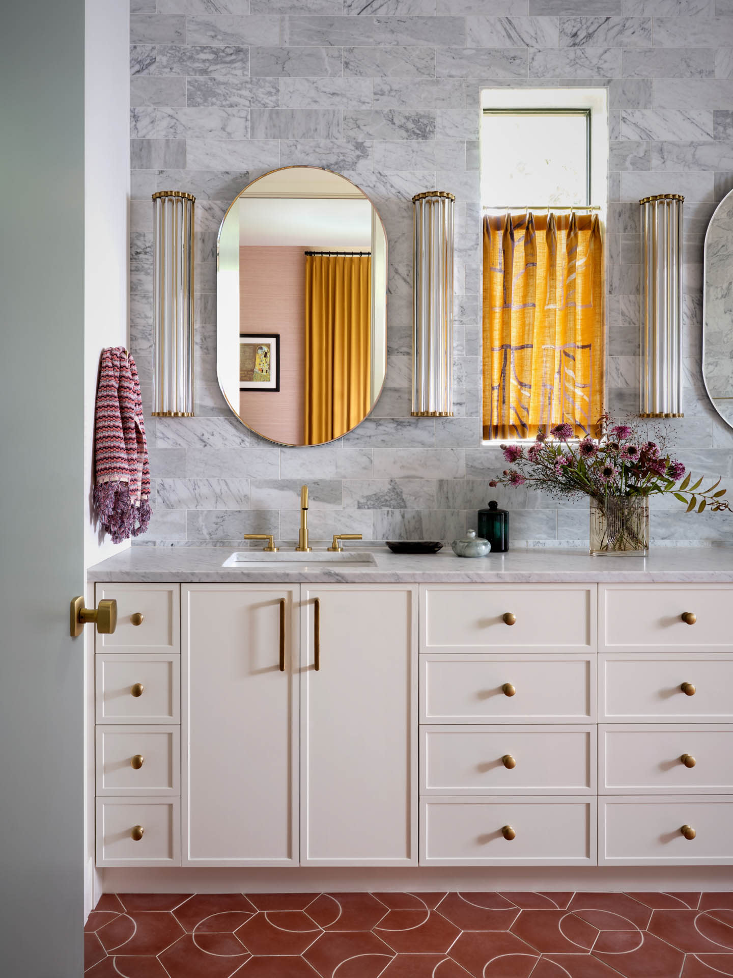 light pink vanity atop red floor tiles in a gray bathroom