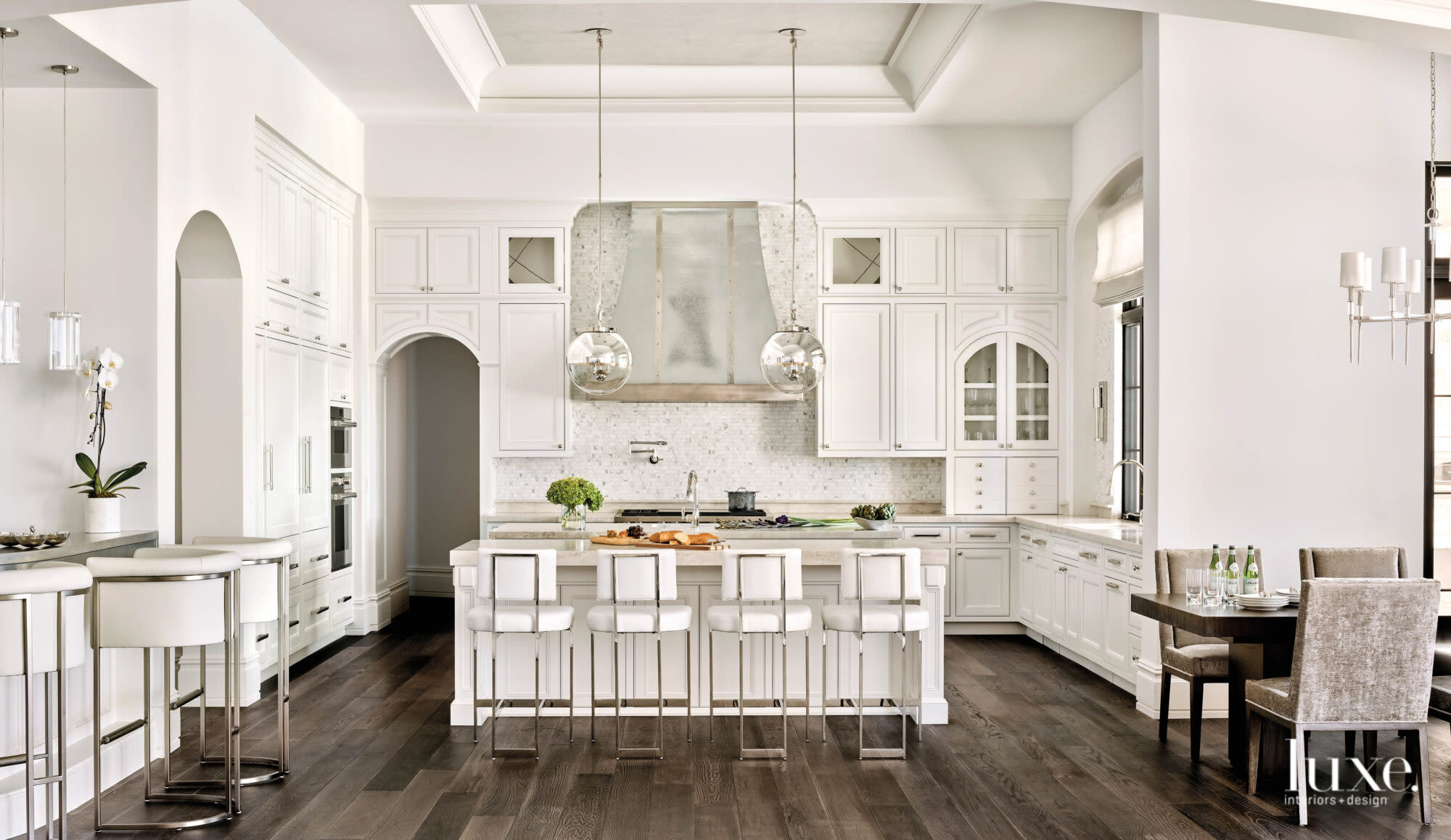 The all-white kitchen features a zinc-and-pewter hood.