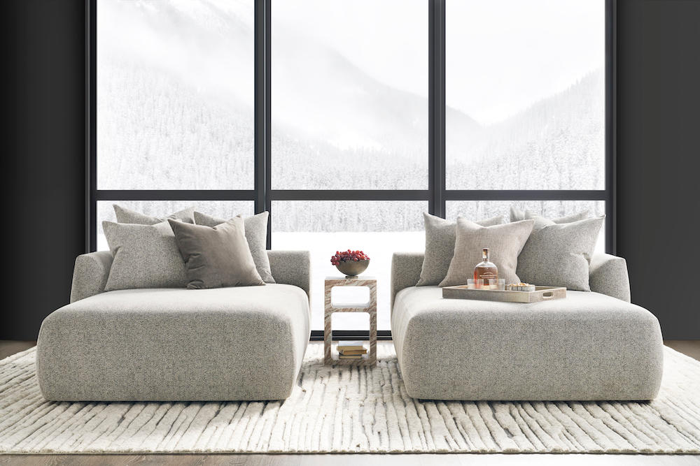 A stylish living room showcasing two couches positioned around a table, designed for relaxation and social gatherings.