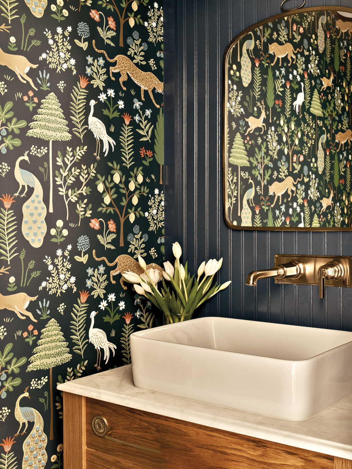 powder room with patterned wallpaper and blue beadboard and wall-mounted faucet behind the vanity