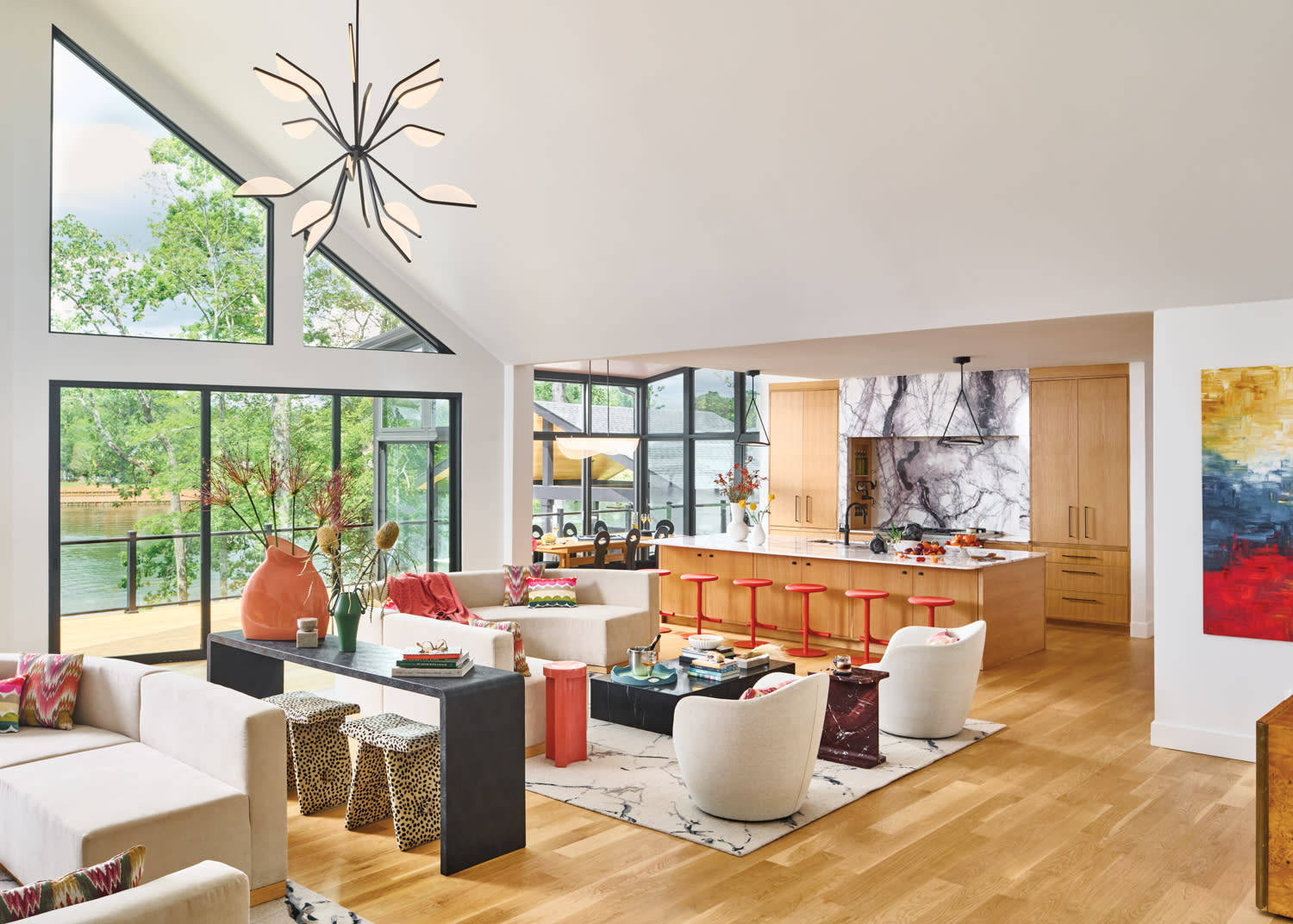 light and bright living room with views of a lake out the floor to ceiling window on one side