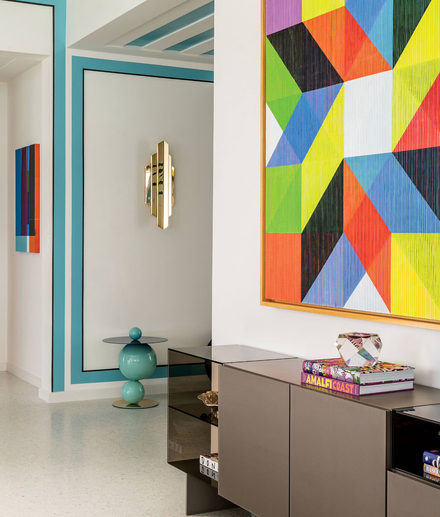 entry hall with a vibrant painting by Antonio Marra over a glass Lago sideboard