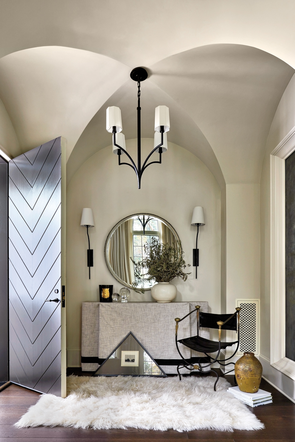 Entryway with arched ceiling details and curated collection of furnishings and art