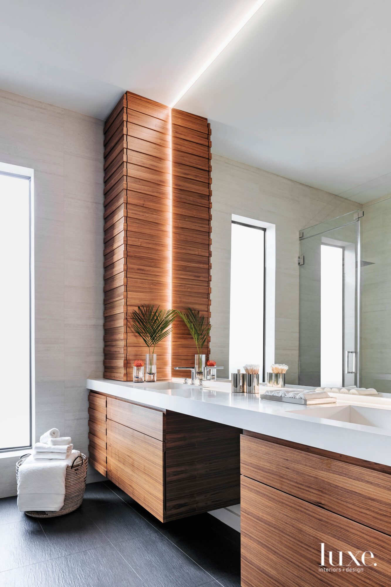 Bathroom with walnut cabinetry and white quartz countertops.