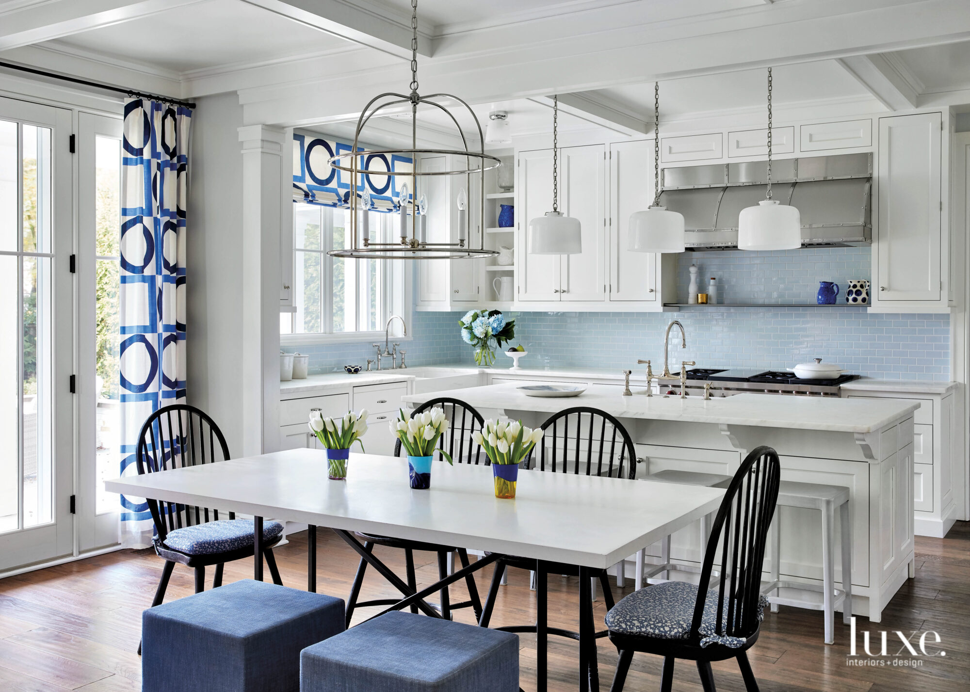 all white kitchen with blue curtains, stools and backsplash