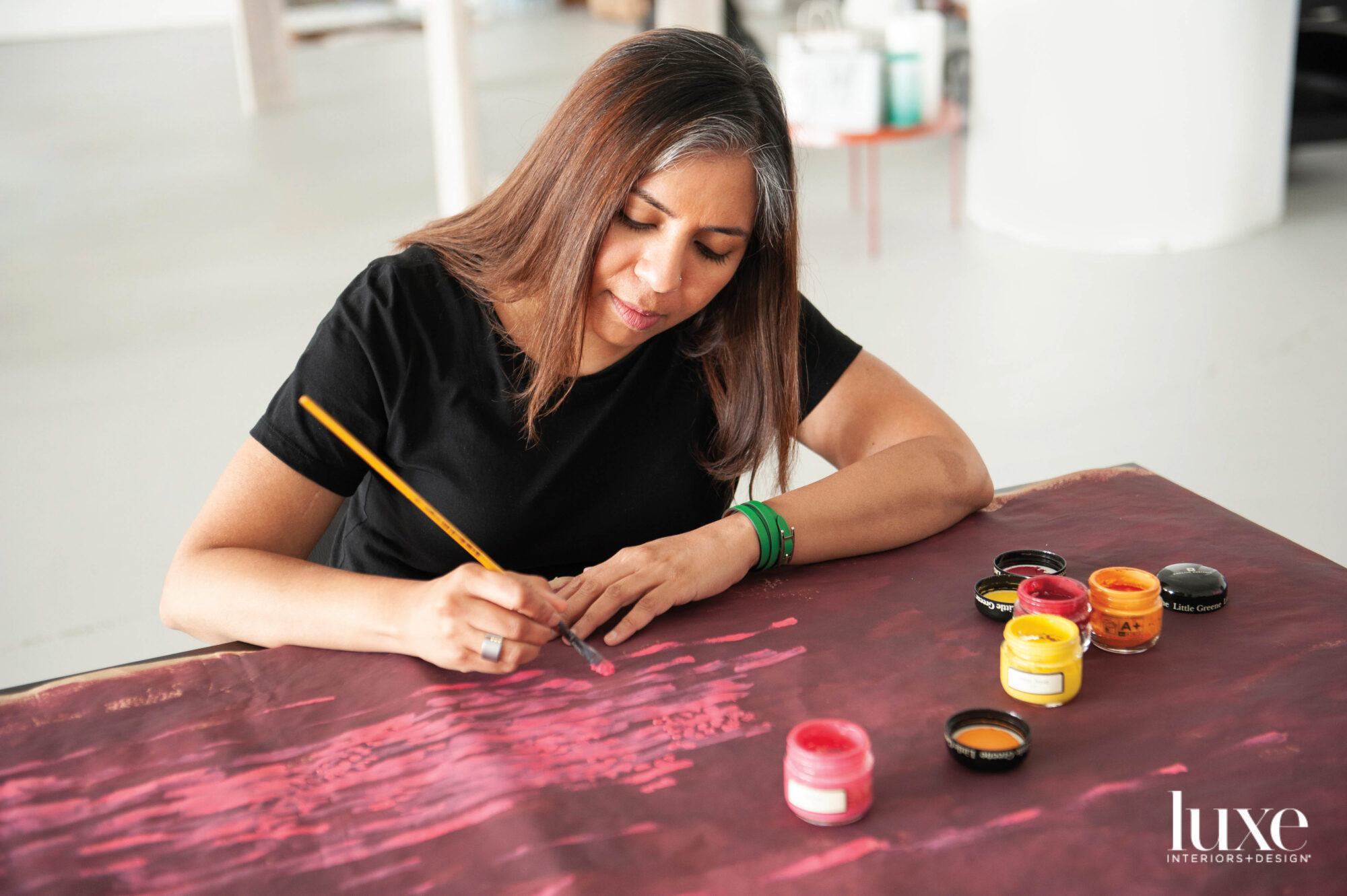 An Indian artist painting on a large piece of paper.