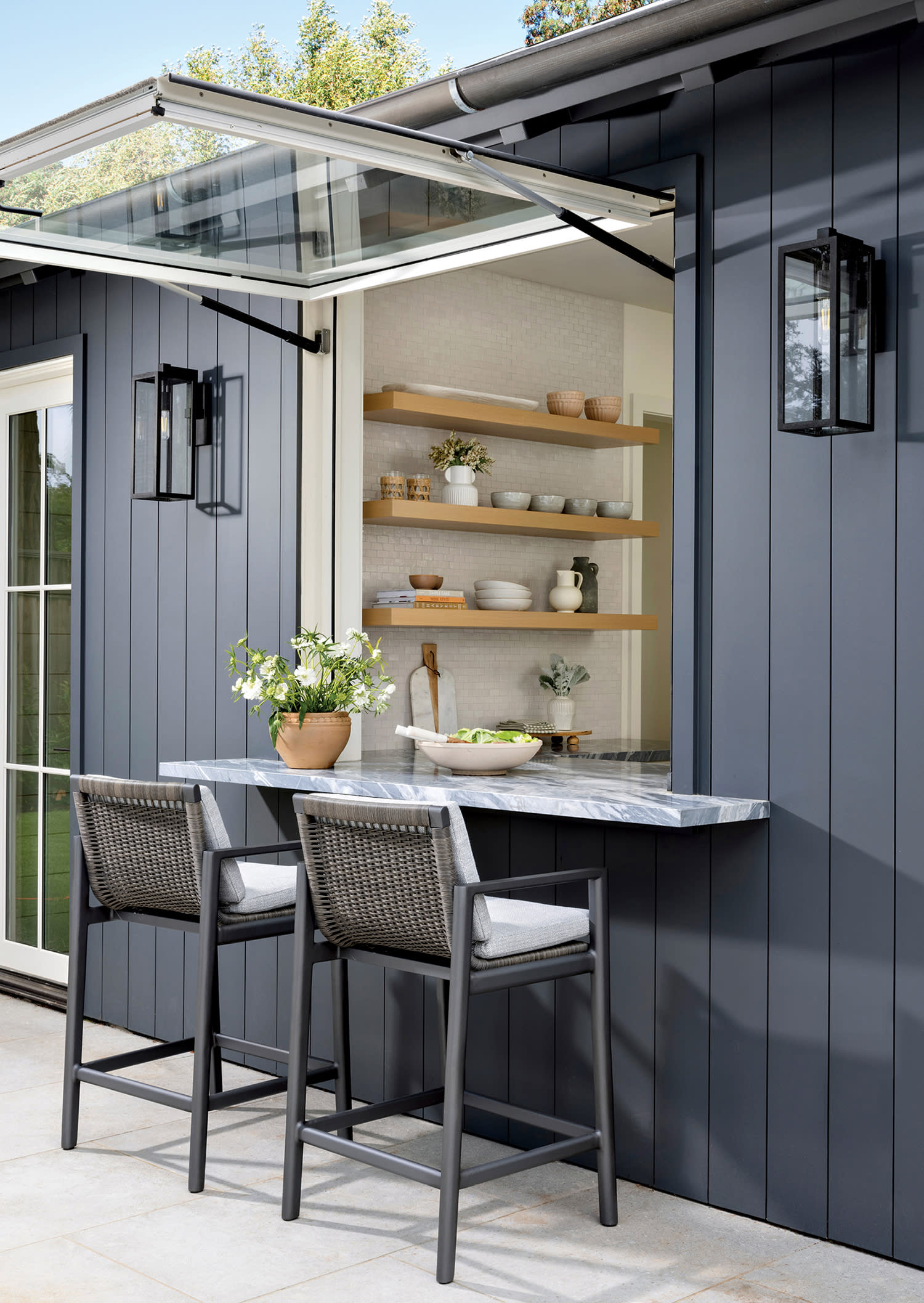 marble countertop beneath an open window allowing for indoor/outdoor dining at a pool cabana