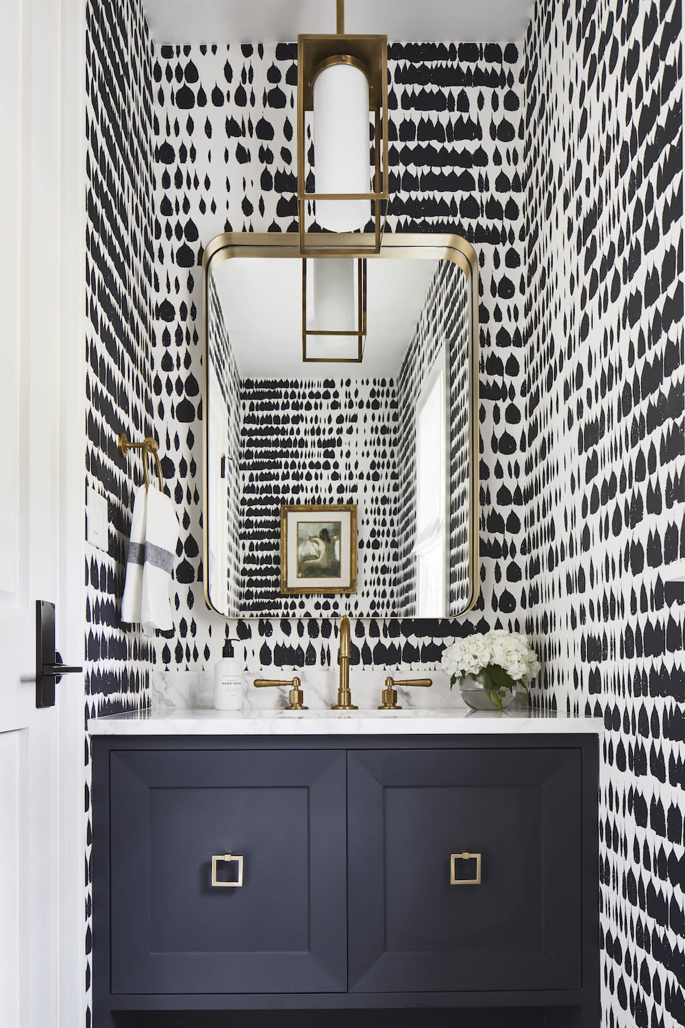 Powder bath with bold black and white wallpaper. 