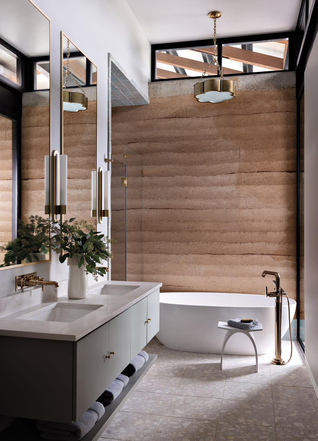 bathroom with rammed-earth walls and Ann Sacks tile flooring