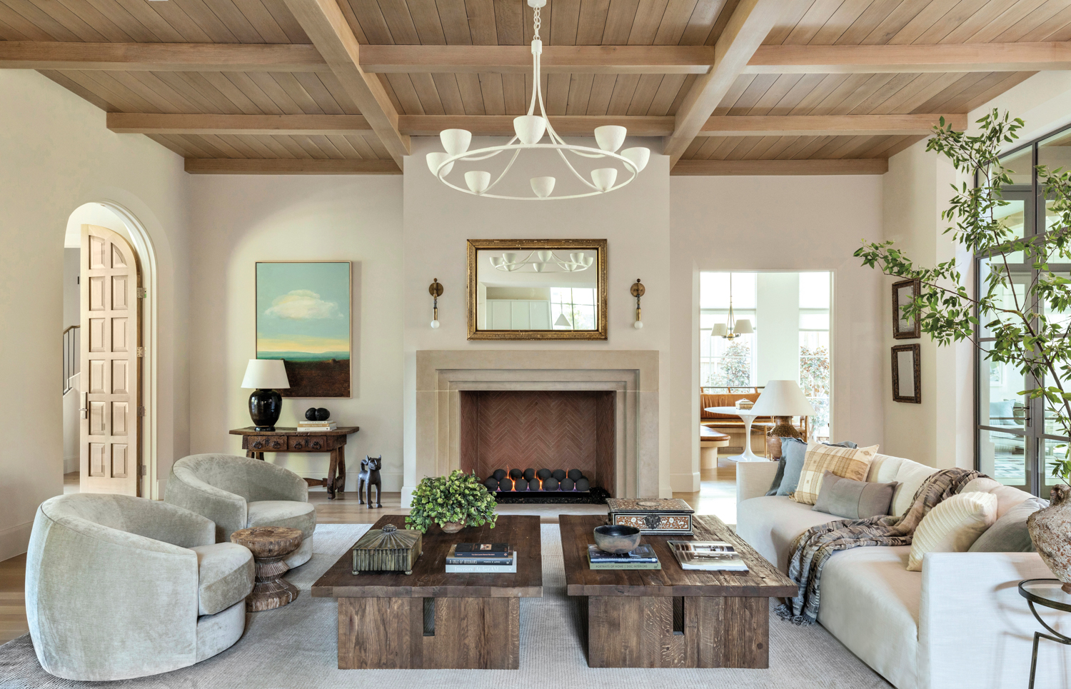 expansive neutral living room with two coffee tables, wood accents and coffered ceilings