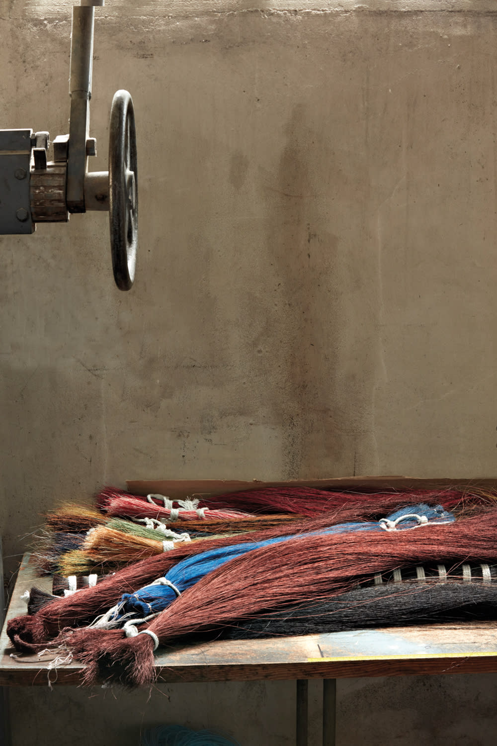 bundles of horsehair in different colors with loom in workshop by Métaphores