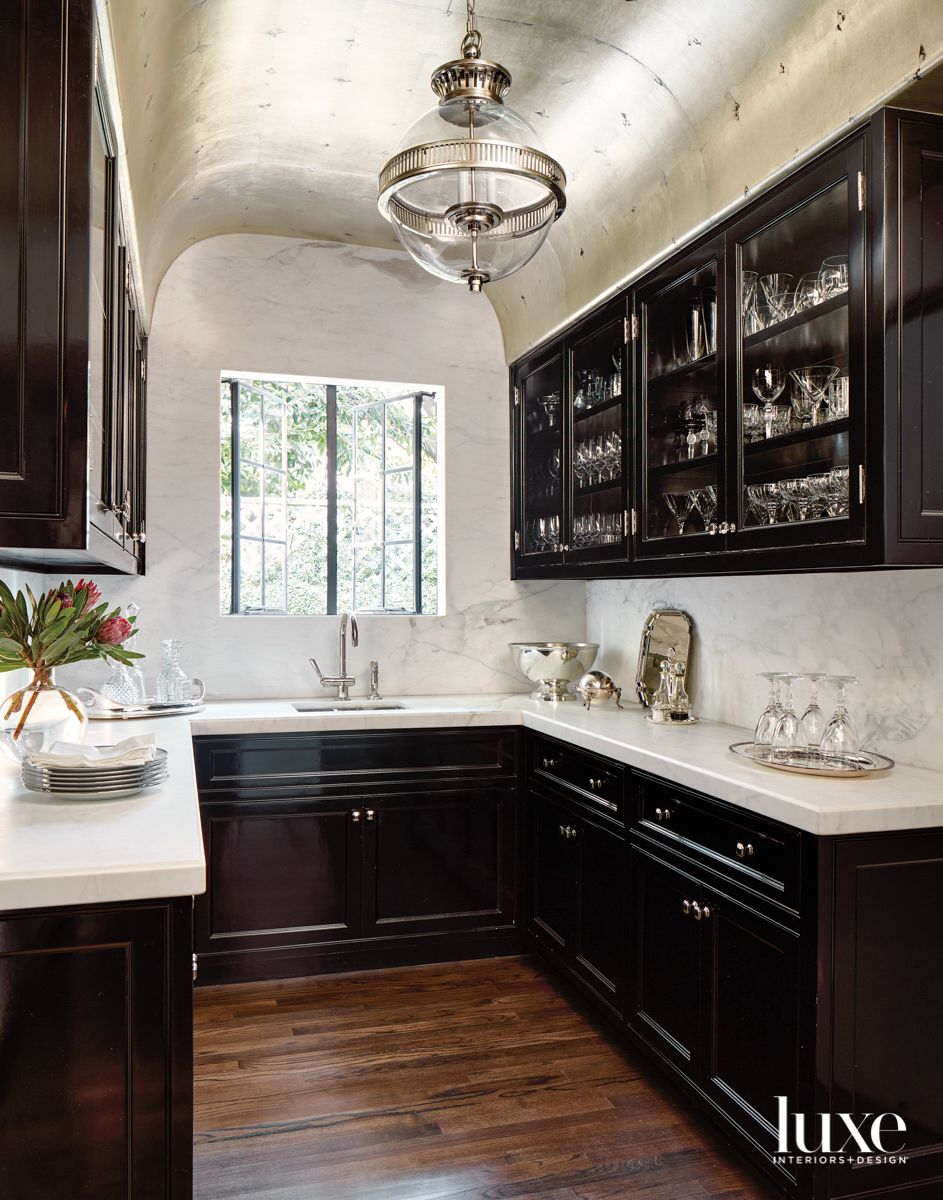 Pantry with black-painted cabinetry and silver leaf ceiling