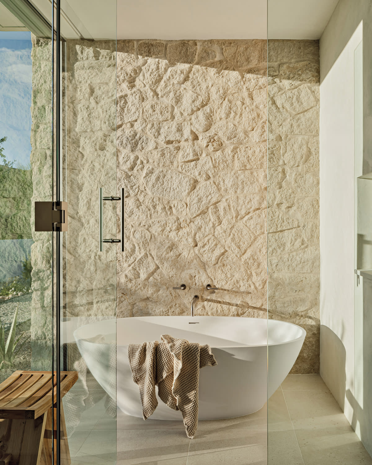 bathroom with a Turkish stone wall and views of the Arizona desert outside