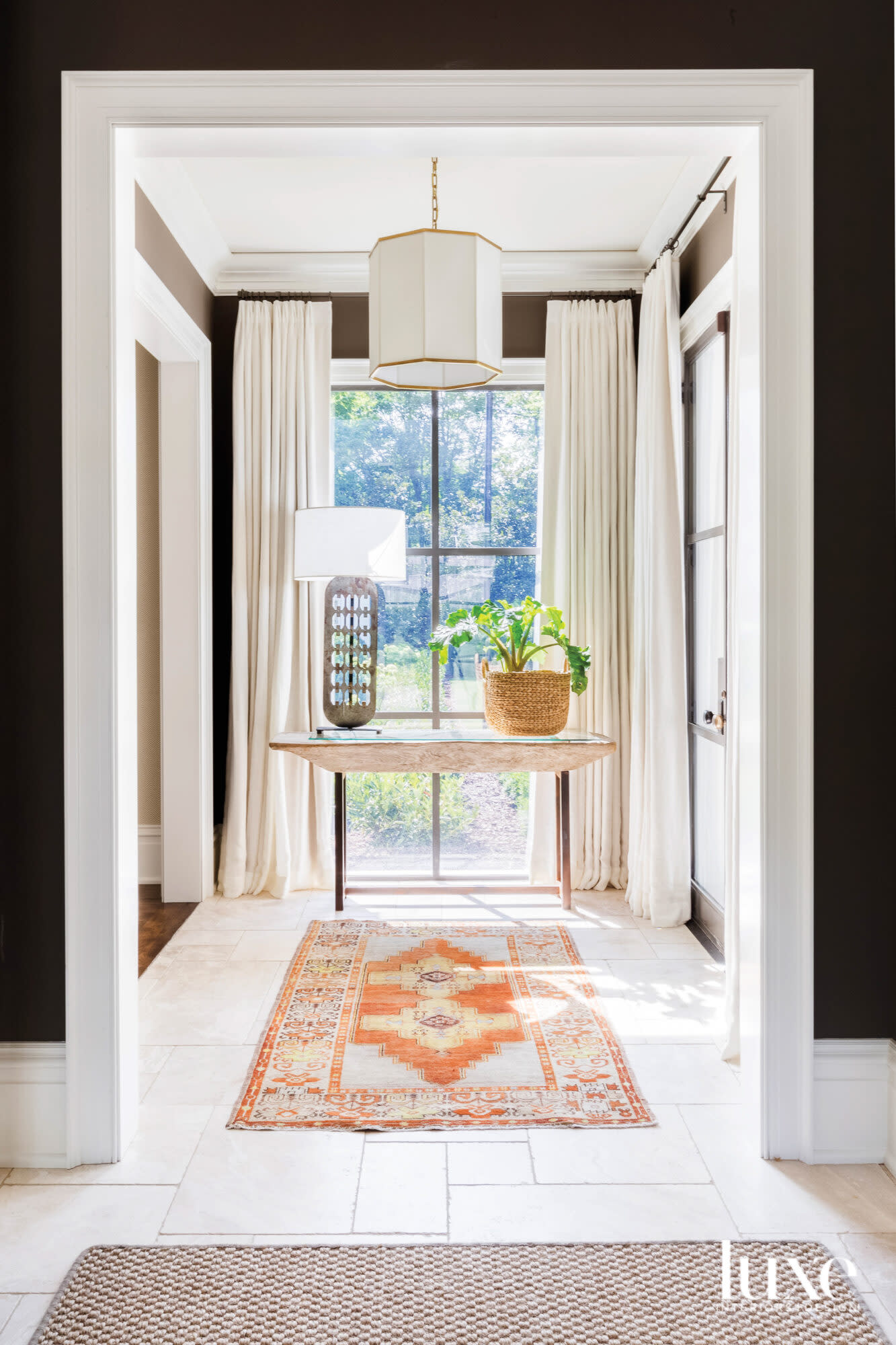 Hallway with orange rug, ivory draperies and espresso-colored walls