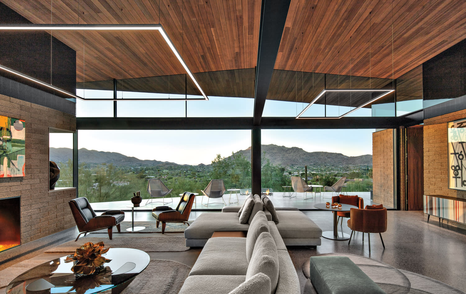 open plan living room with midcentury-modern-style furnishings and floor-to-ceiling windows with mountain views