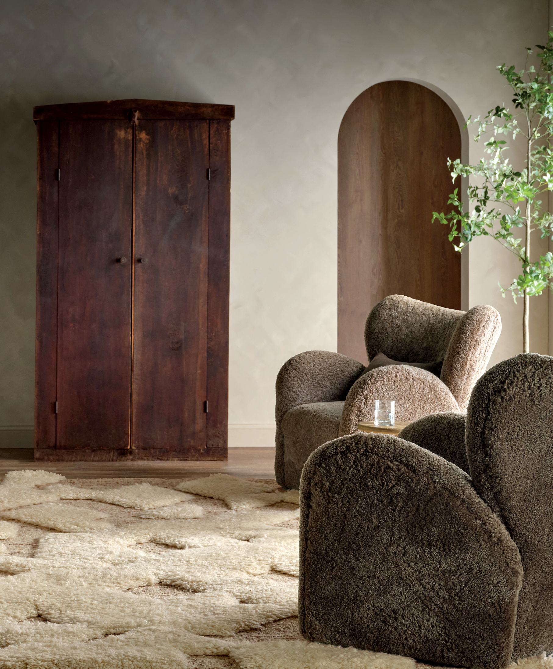 neutral living room with a textured off-white rug and brown boucle armchairs