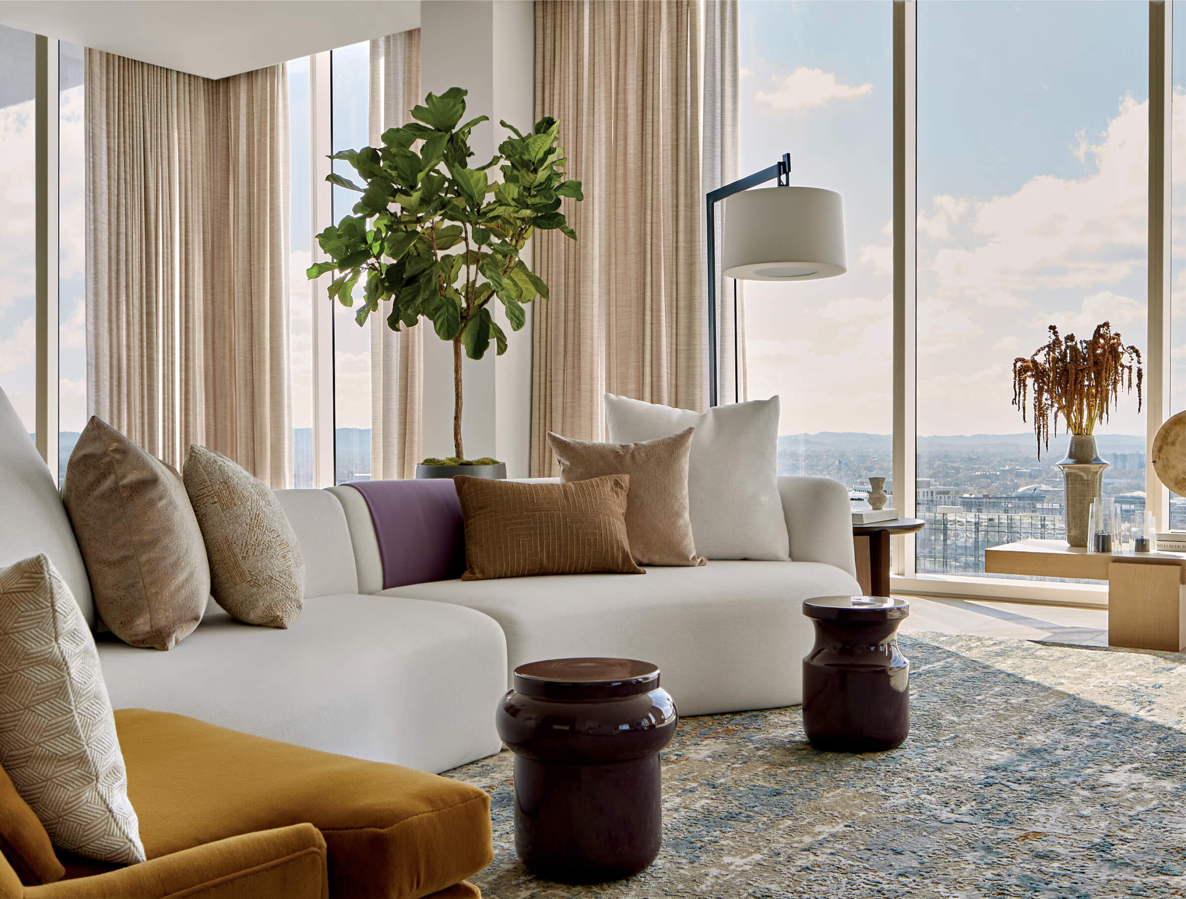 white sectional in front of a tall plant in a living room