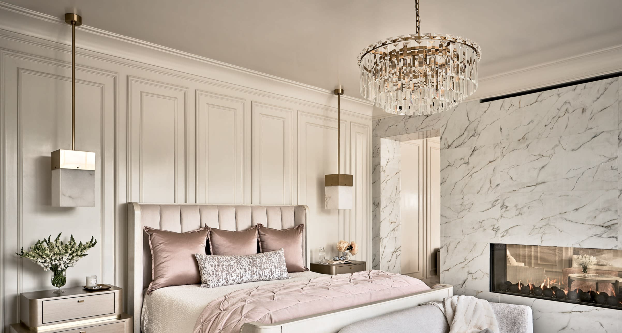 luxurious modern bedroom with a chandelier and hanging pendants beside the bed
