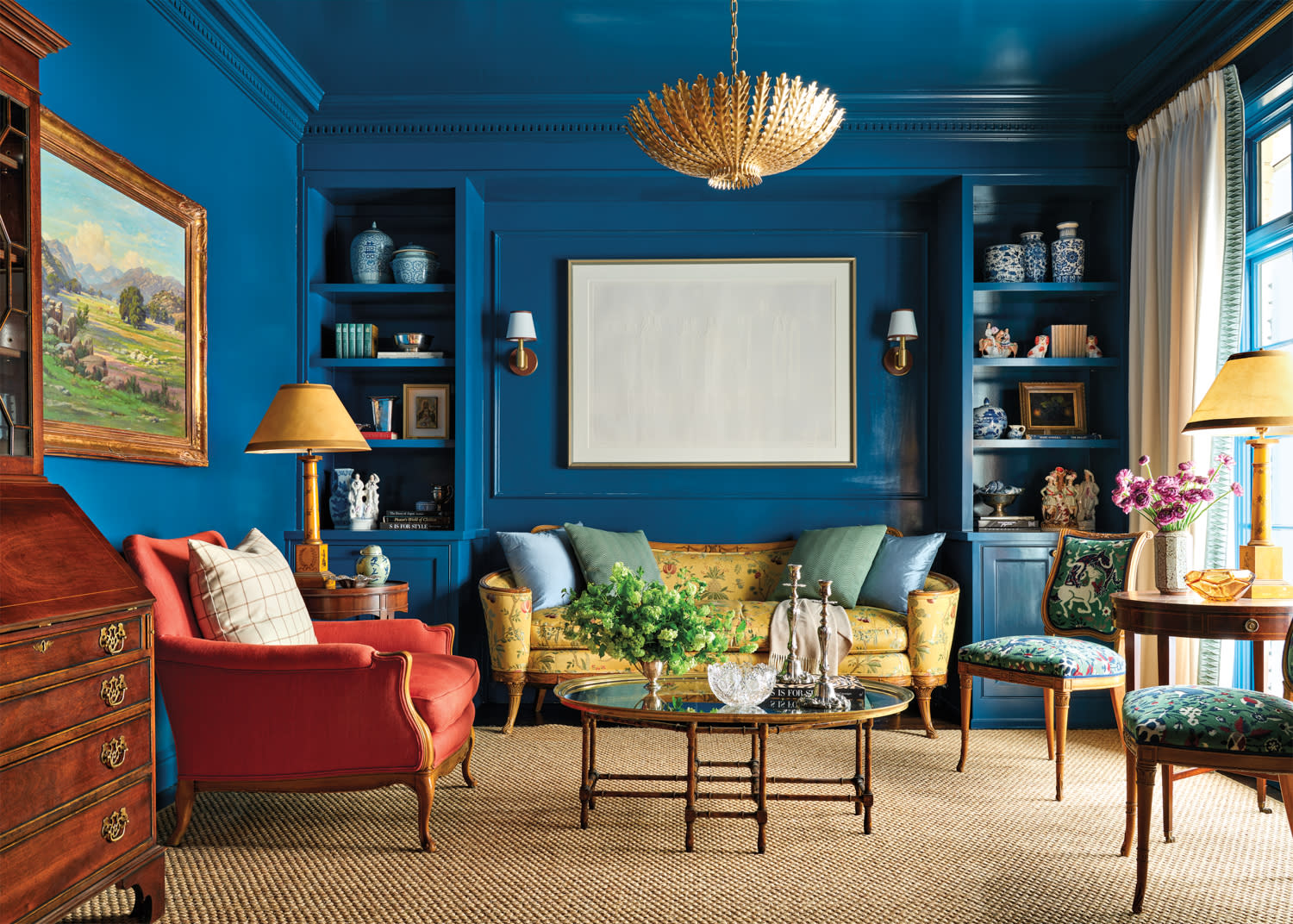 Blue living room with built-in shelving, armchairs and sofa