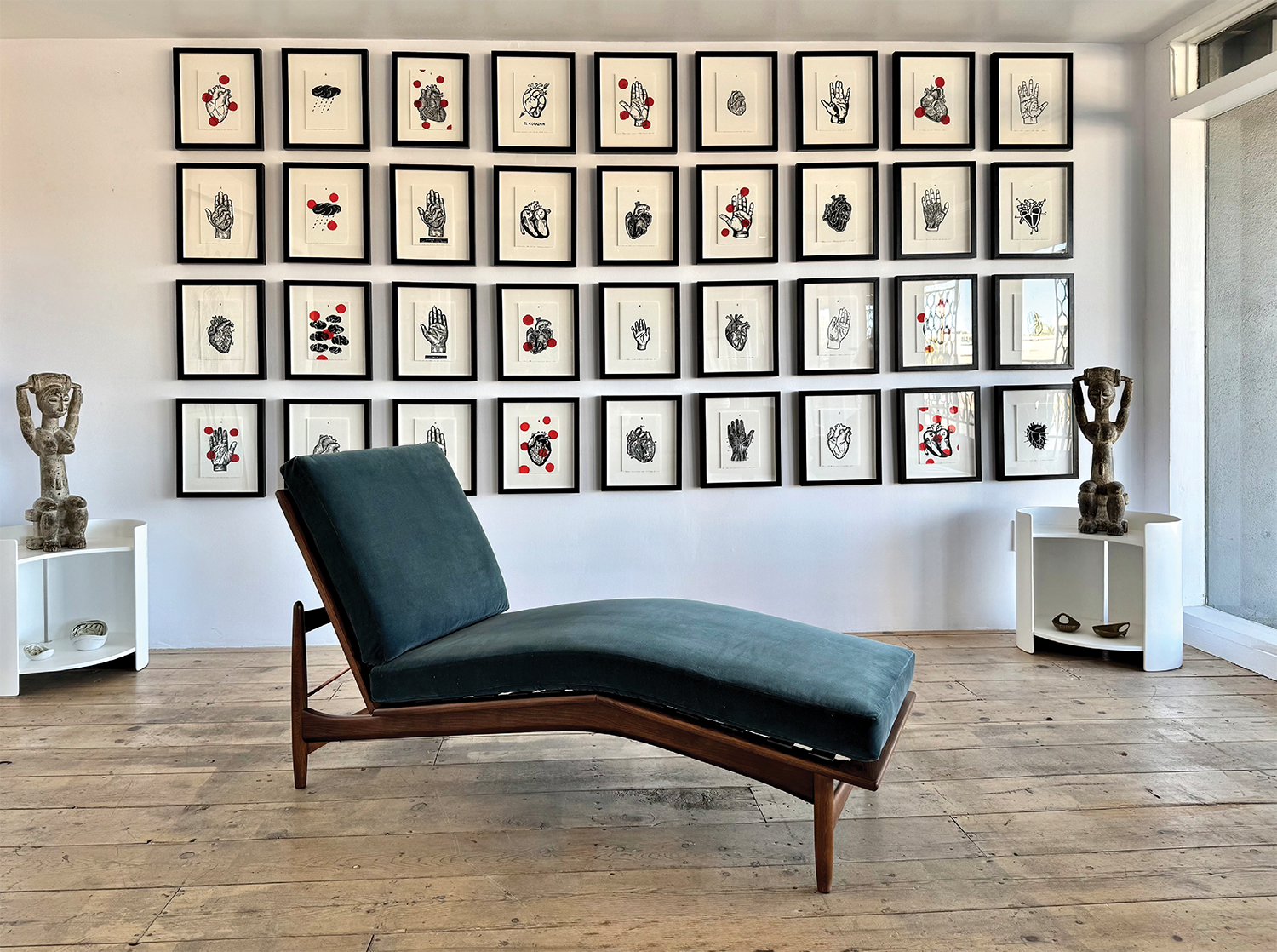 midcentury-style lounger in front of a gallery wall of prints