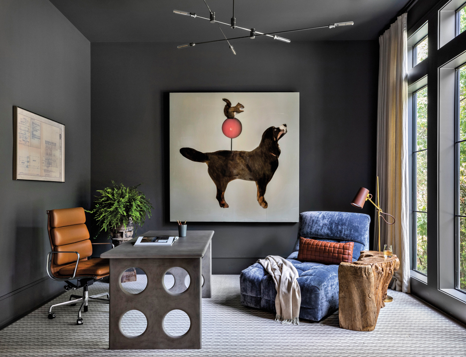 study with dark gray walls, gray desk with circle cutouts, brown chair and a custom pet portrait