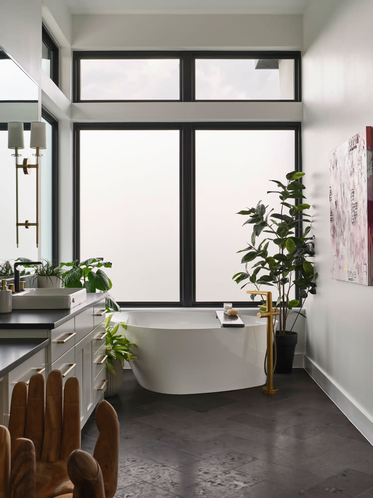 Polished and refreshed, this primary bath combines natural elements with refined finishes, creating a spa-like atmosphere. Natural light gracefully highlights the elegant freestanding tub. 
Photography by Andrea Calo.