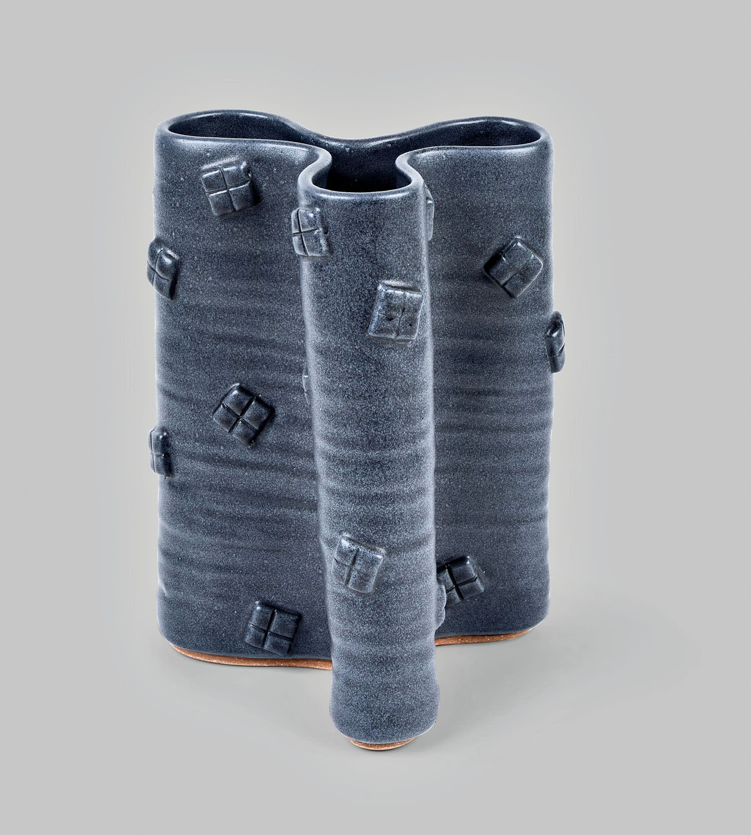 Angular ceramic dark blue vase on a white background.