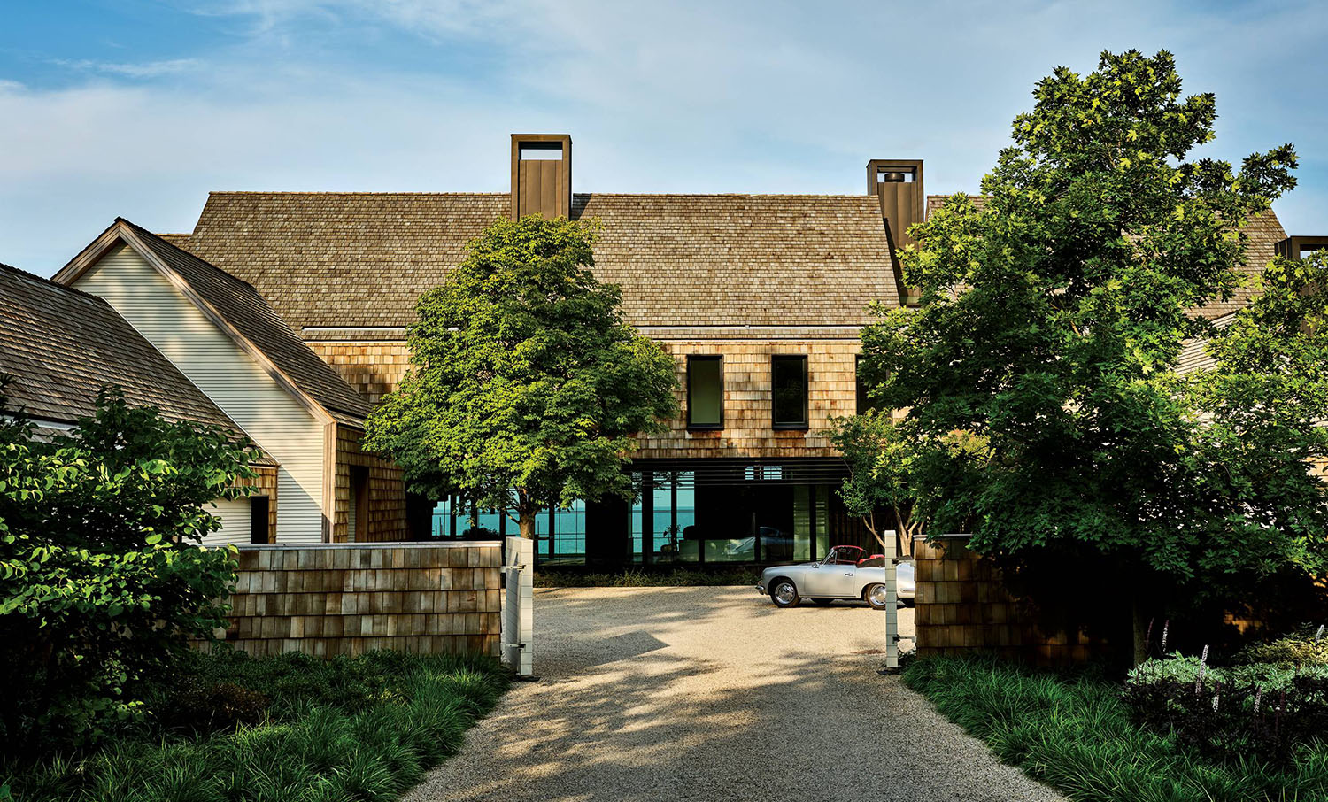 cedar-shingled home exterior with a classic car in the driveway