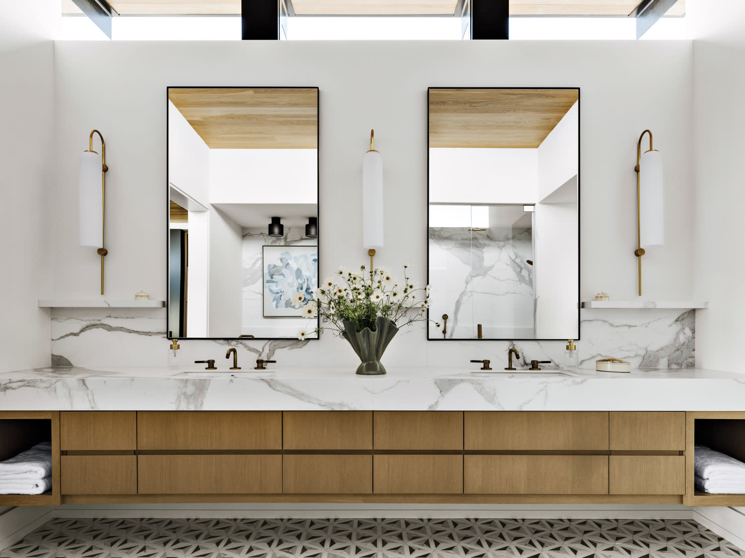 contemporary bathroom with an oak vanity topped by a white marble countertop