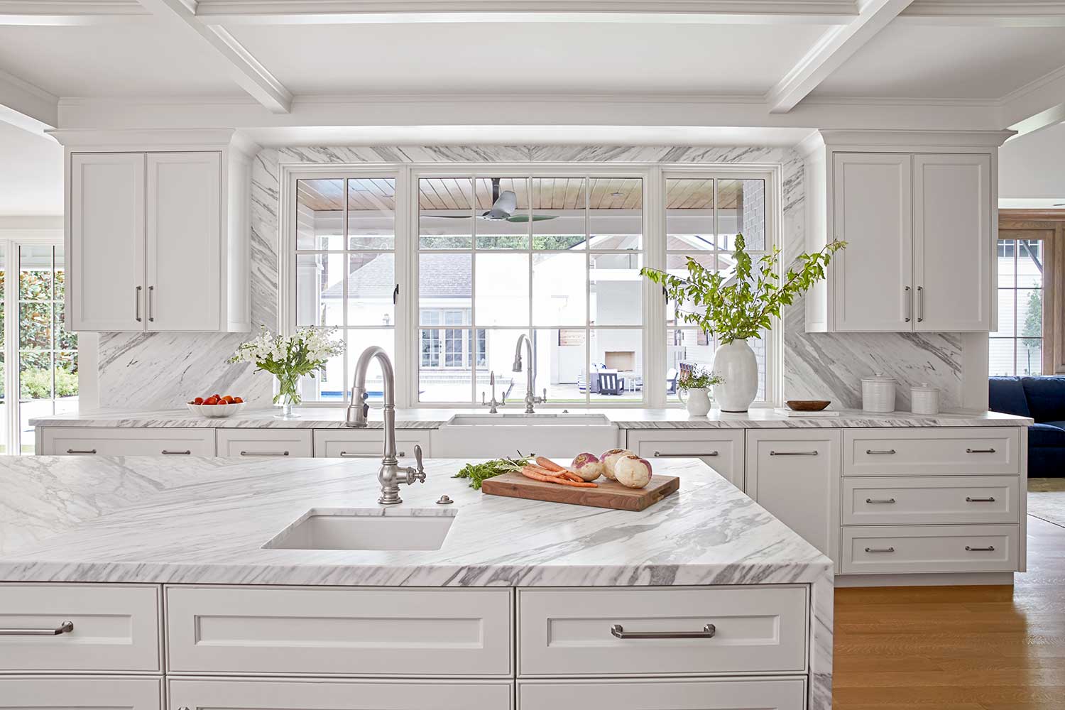 kitchen with white cabinetry, light gray countertops and backsplash and light wood flooring