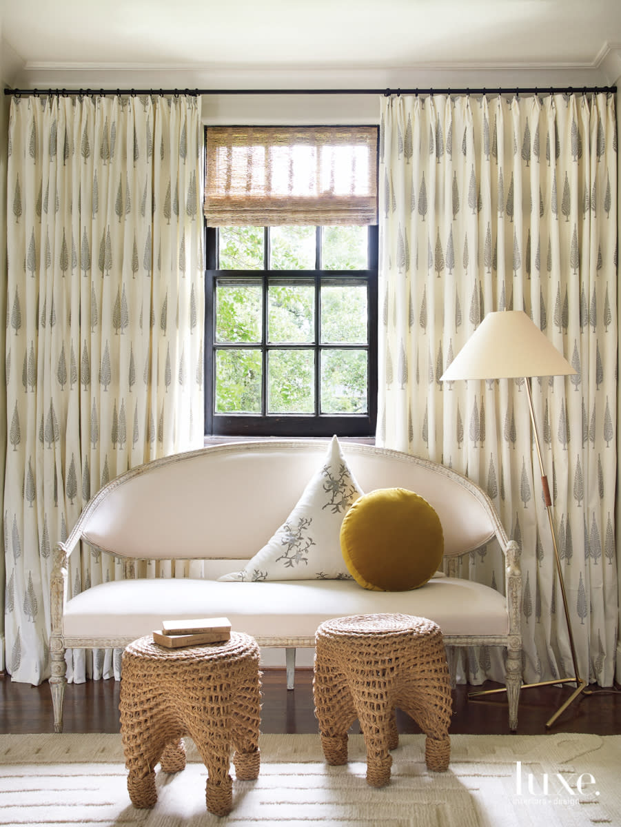 Master bedroom seating area featuring a Gustavian bench and custom draperies