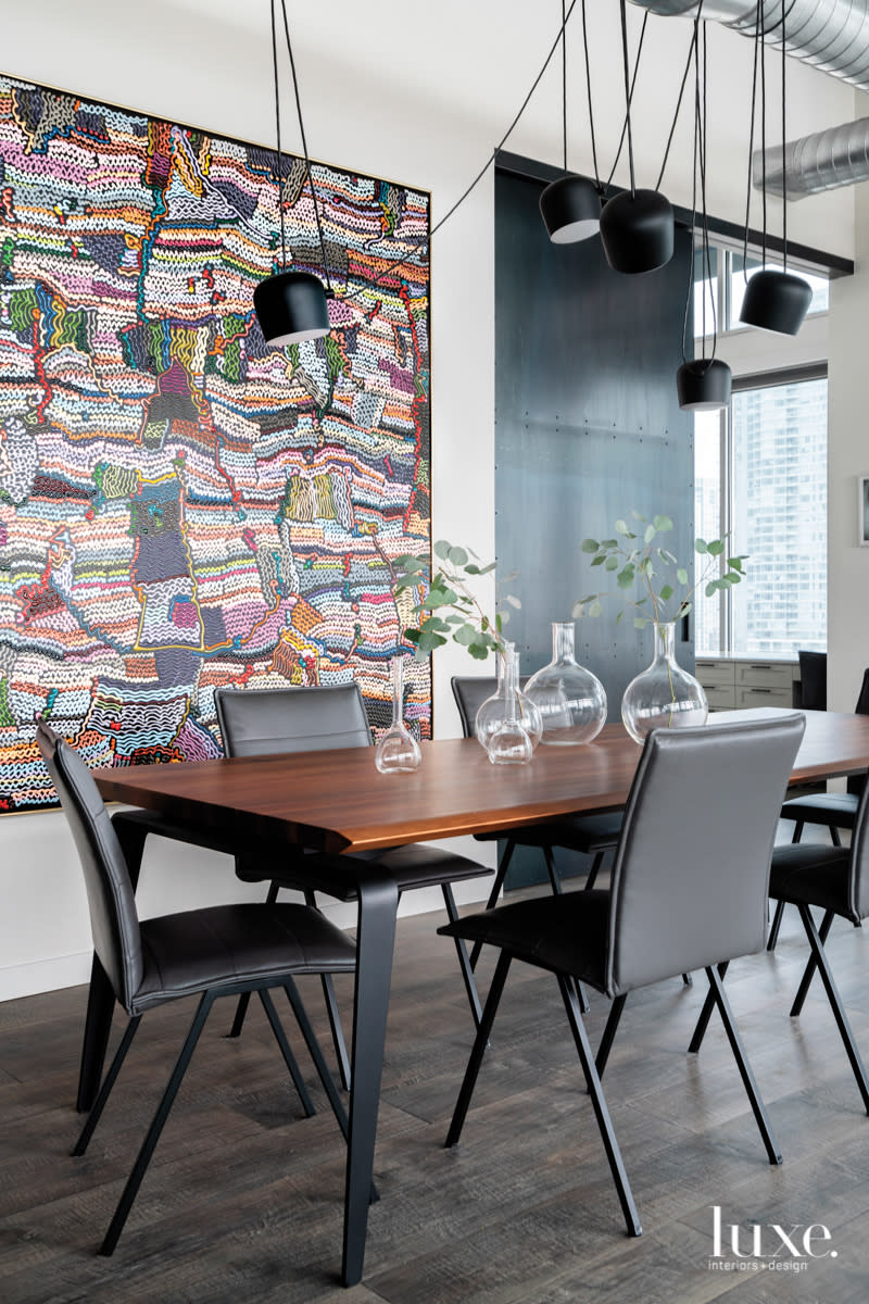 dining rom with black pendants around exposed ductwork