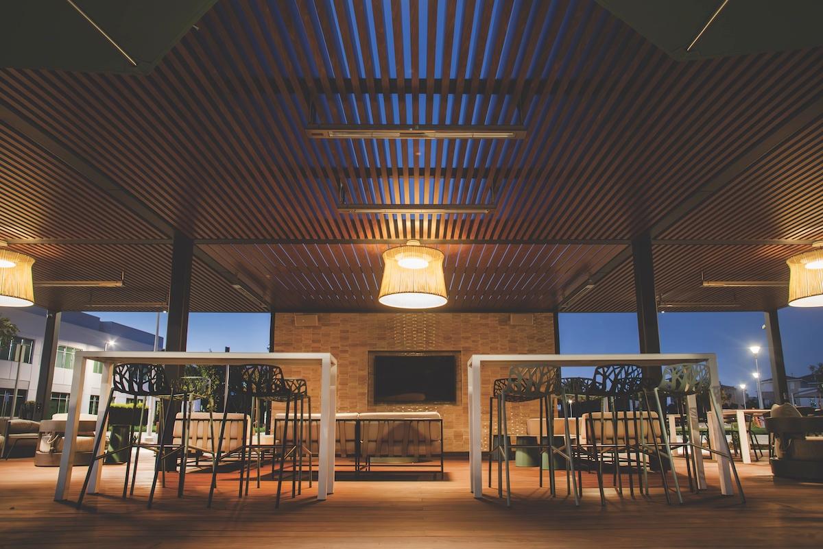 An expansive outdoor setting with a wooden ceiling and illuminated lights enhancing the ambiance.