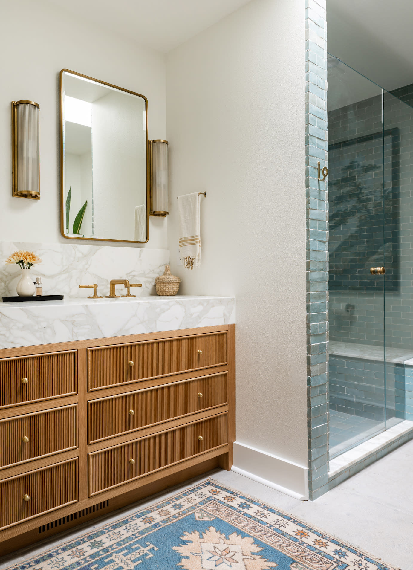 bathroom featuring a wood vanity and colored tile shower