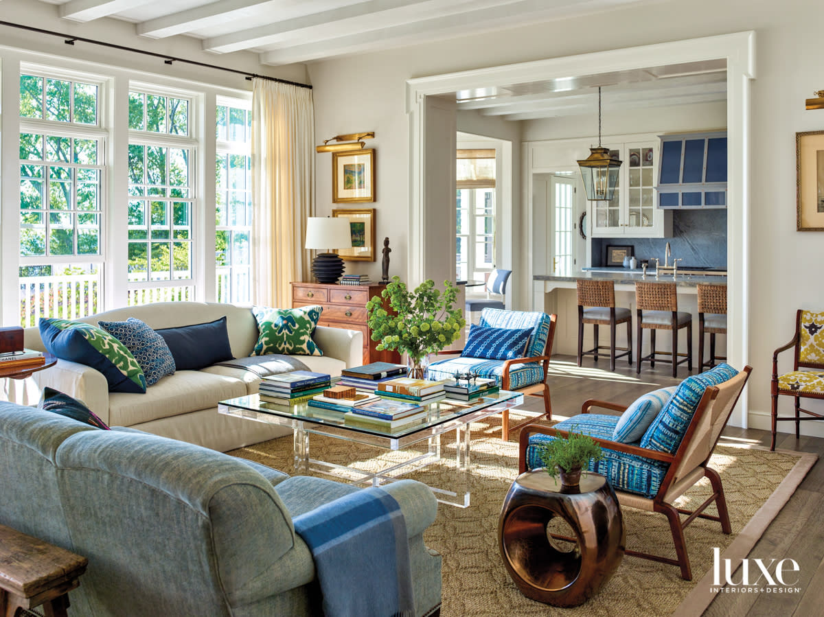 A seating area with blue and tan furniture off a kitchen.