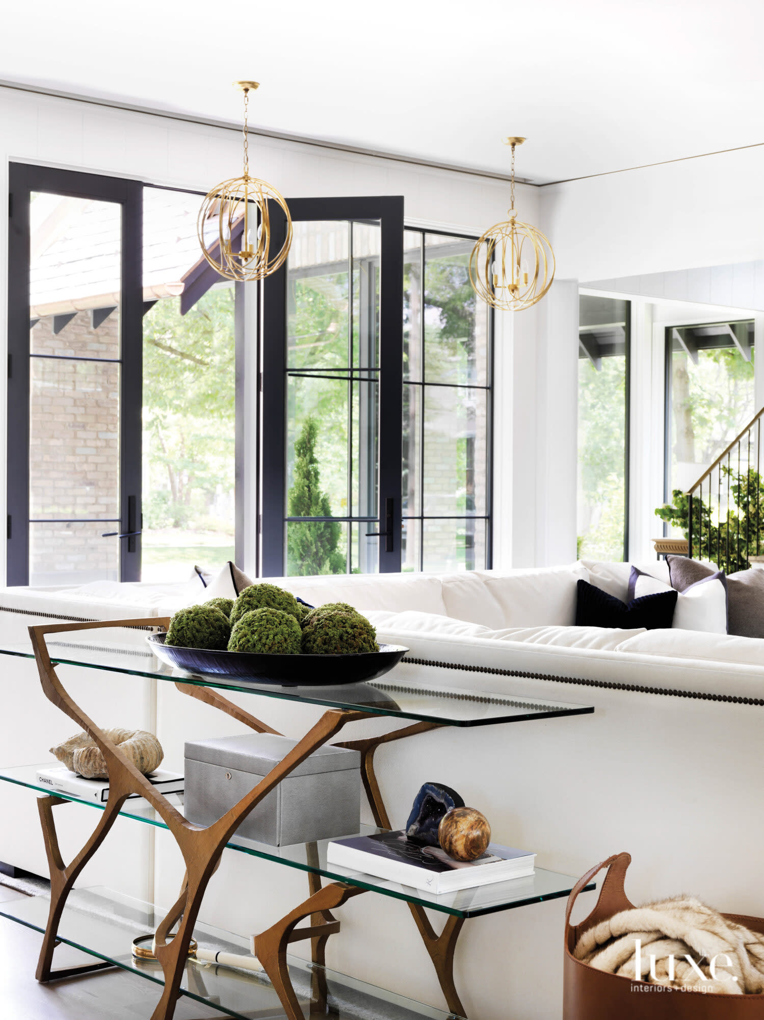 A white sectional in the living room, which opens to the outside.