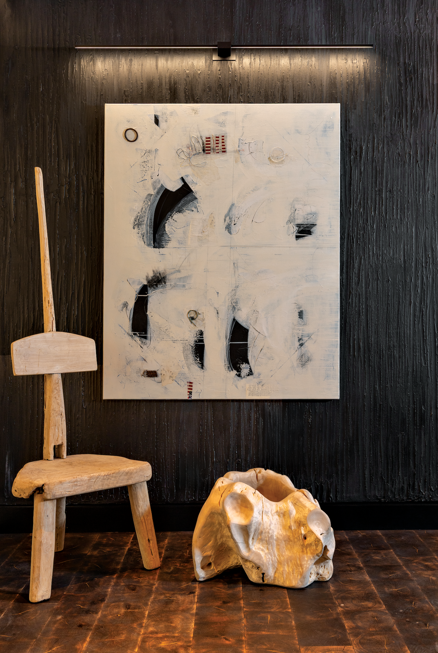 Textured dark gray wall displaying contemporary resin artwork in a moody interior setting.