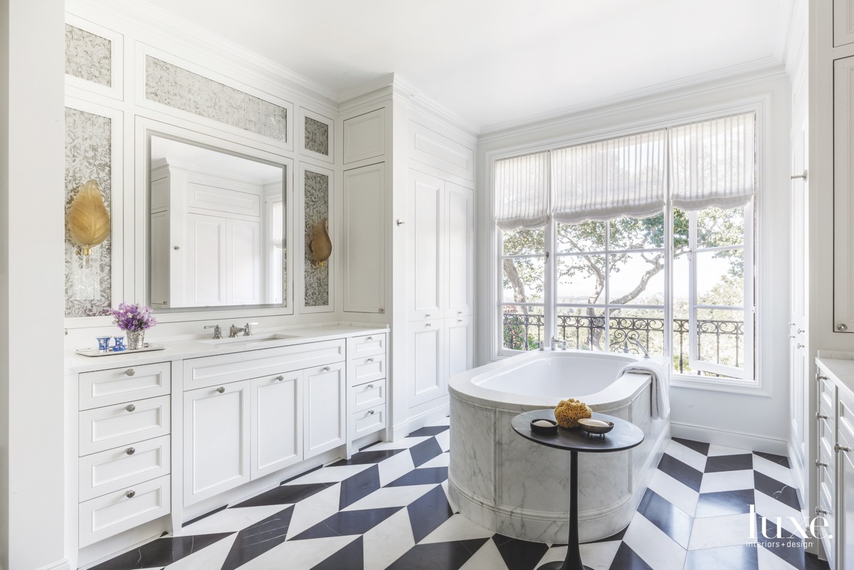 coastal white bathroom black and white patterned tile floor marble tub