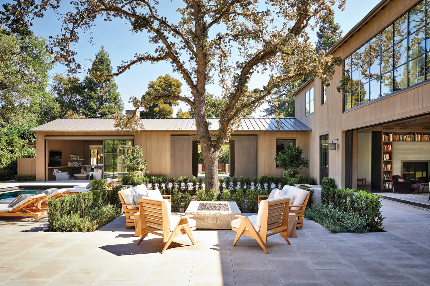 backyard with large tree, teak furniture and fireplace