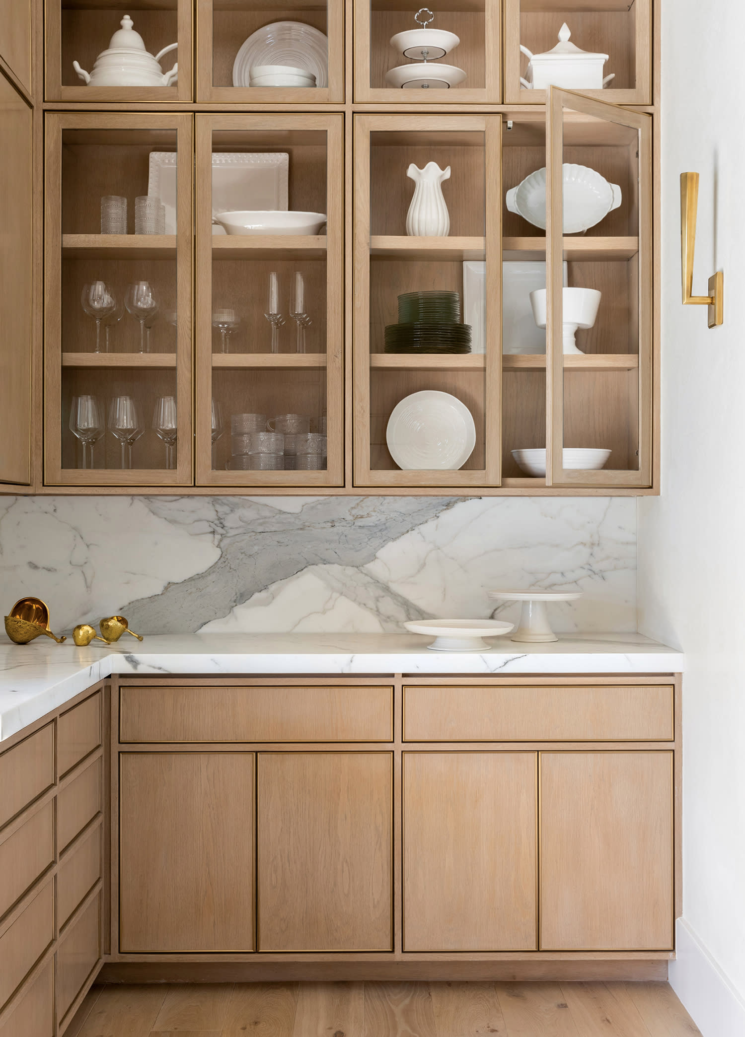 pantry with white oak cabinetry and marble countertops