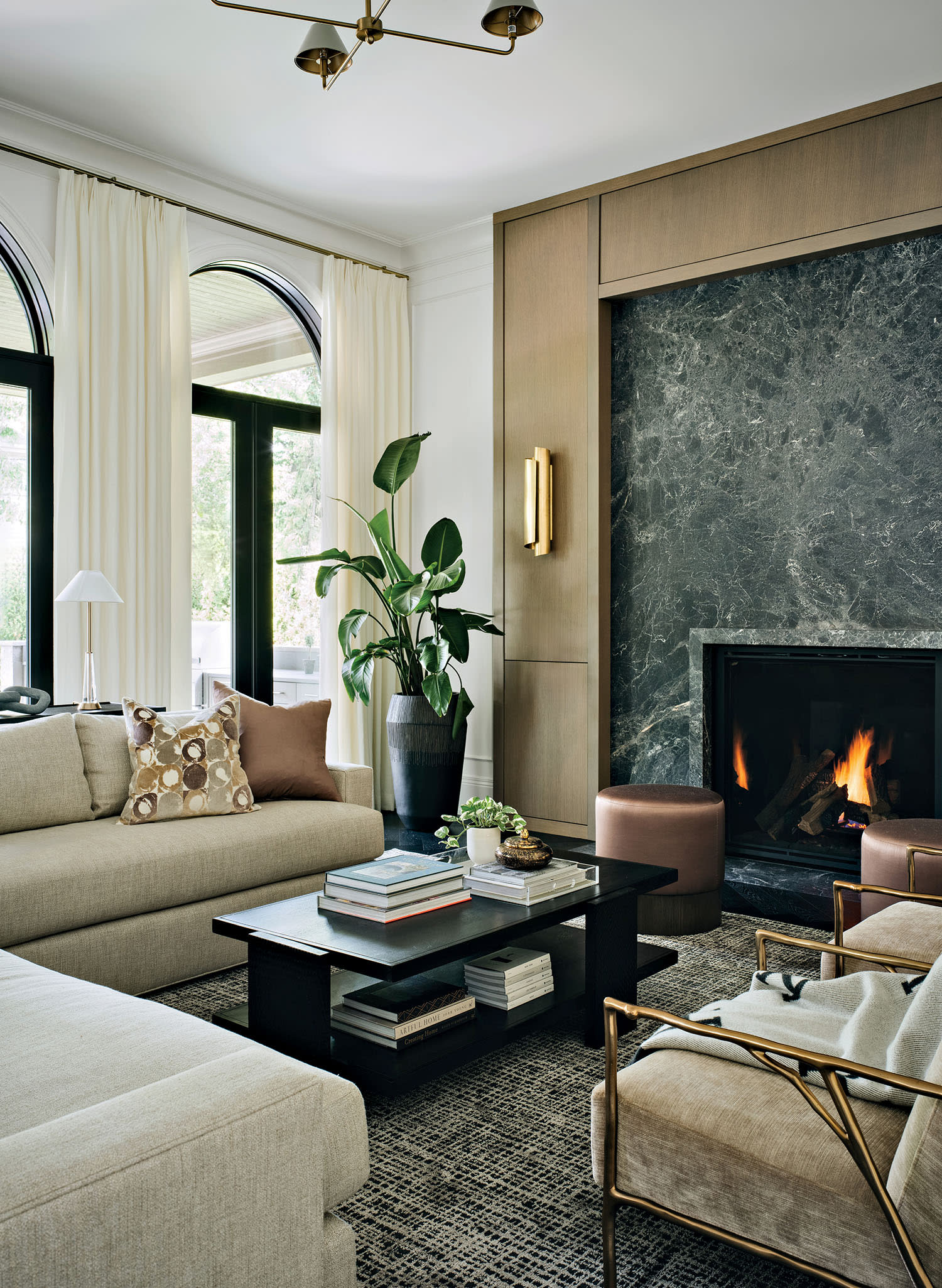 traditional family room with white sectionals and a marble-clad fireplace