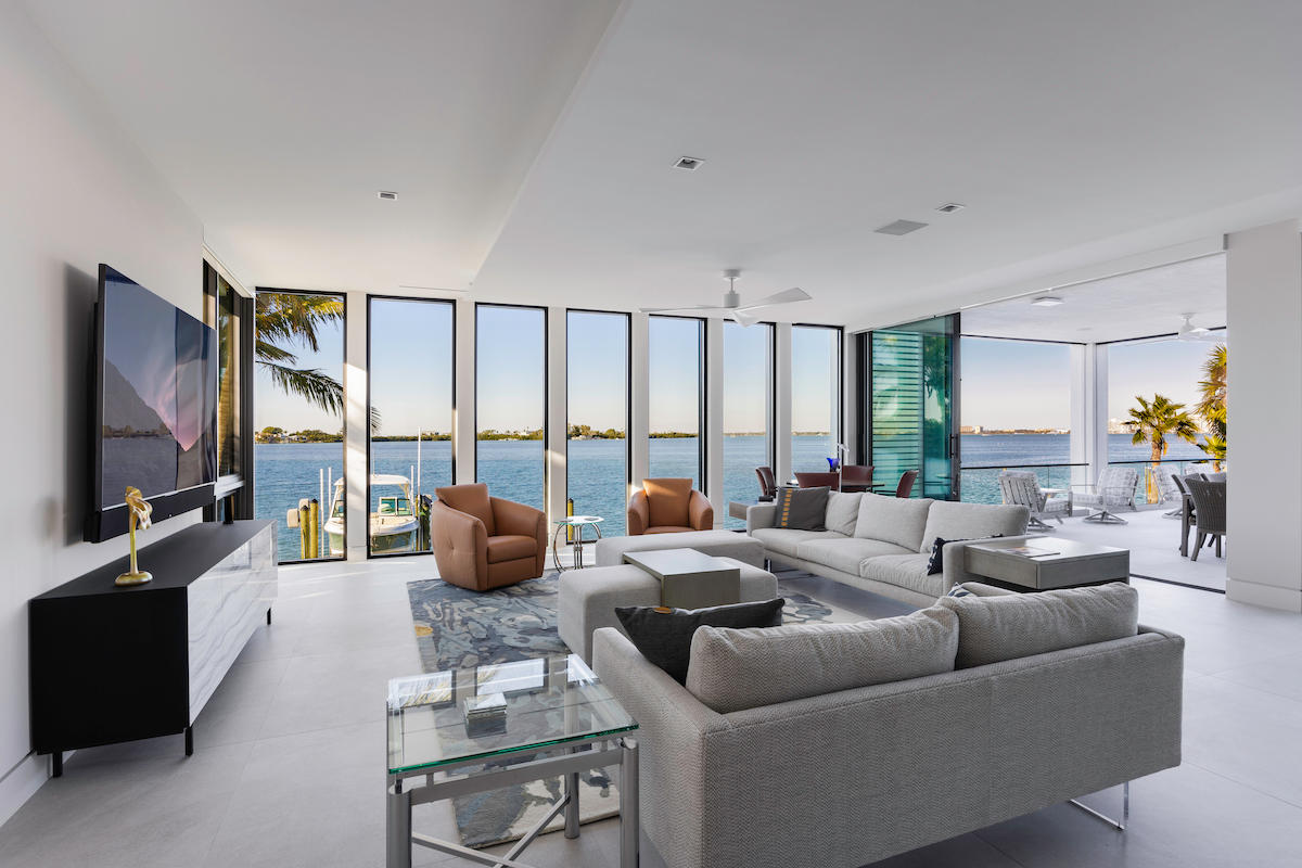 Room with panoramic water views through oversized windows.