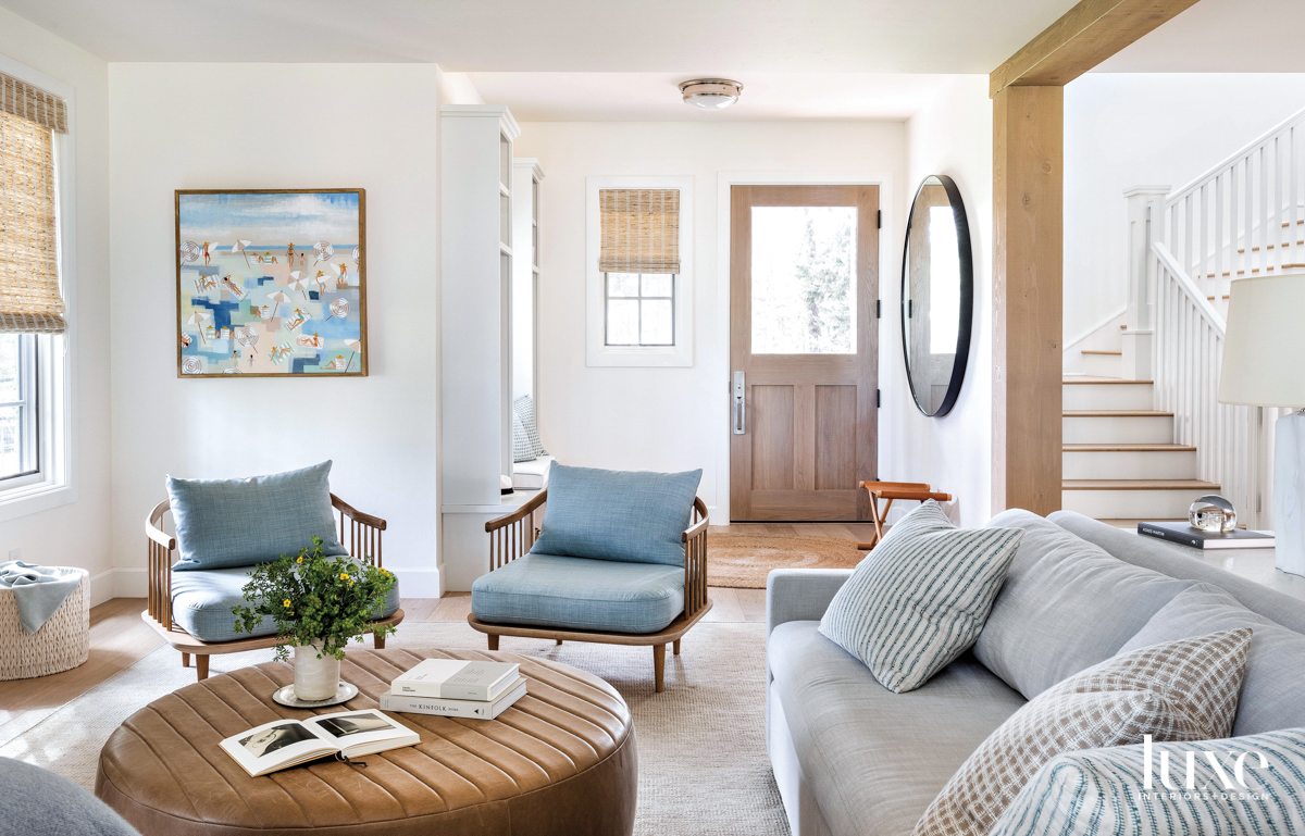 Living room with large round ottoman and wood frame lounge chairs